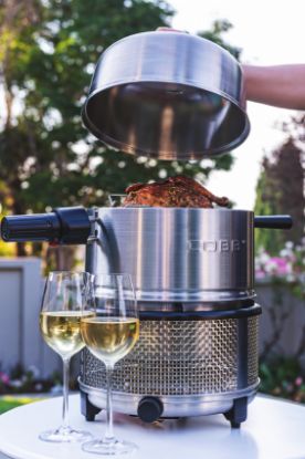 Garden table with Cobb Premier+ Gas cooking a Rotisserie Chicken