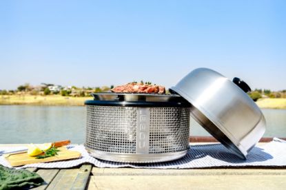 Steak cooking on Cobb griddle in river bank